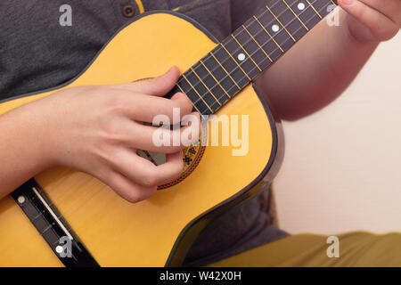 Gros plan du jeune homme mains jouer ukulele Banque D'Images