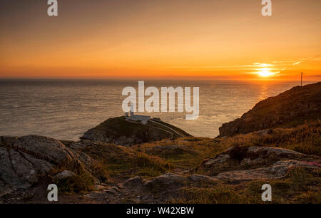 Coucher de soleil au phare de South Stack sur l'île d'Anglesey, au Pays de Galles UK Banque D'Images