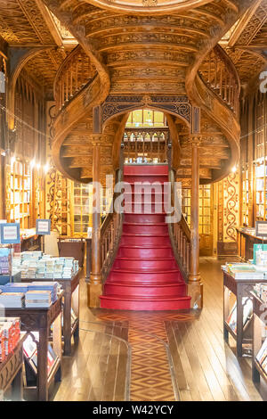 Grand escalier en bois avec des actions à l'intérieur rouge et Irmao Lello Bibliothèque dans le centre historique de Porto Banque D'Images
