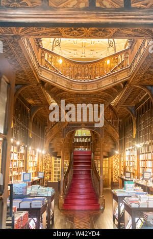 Grand escalier en bois avec des actions à l'intérieur rouge et Irmao Lello Bibliothèque dans le centre historique de Porto Banque D'Images