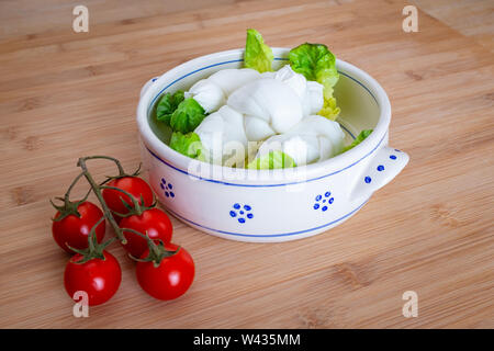 Composition de tomates, salade et fromage mozzarella au lait de vache à la main dans les Pouilles, Italie Banque D'Images
