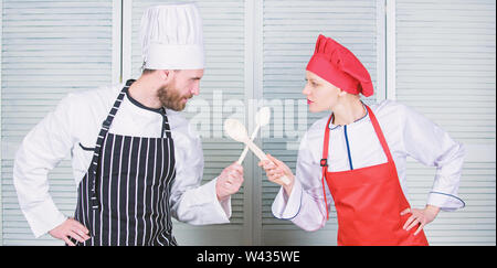 Cuisine ultime défi. Bataille de deux chefs culinaires. Couple en compétition en arts culinaires Cuisine règles. Bataille culinaire concept. Femme et homme barbu show culinaire concurrents. Qui mieux cuisiner. Banque D'Images