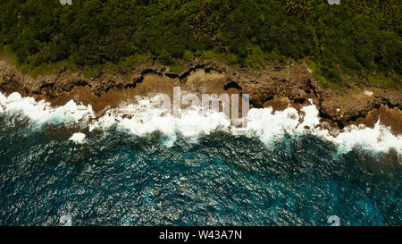 Vagues de l'océan bleu s'écraser contre le rivage et les roches. Siargao, Philippines. L'été et les vacances Banque D'Images