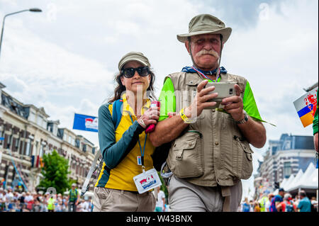 Deux participants traverser la Via Gladiola au dernier km lors de l'événement.puisque c'est la plus grande épreuve de marche de plusieurs jours, les quatre jours le mois de mars est considéré comme le premier exemple d'esprit sportif et les liens entre militaires et civils et les femmes de nombreux pays différents. Cette année marque le 75e anniversaire de la pont flottant qui a été mis en place chaque année sur la rivière Meuse temporairement à Cuijk. Les derniers kilomètres sont à la Via Gladiola Street, où comme le veut la tradition chaque participant porte glaïeul plantes et sont accueillis par des parents et des partenaires. Banque D'Images