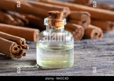 Une bouteille d'huile essentielle de cannelle de Ceylan bâton sur une table Banque D'Images
