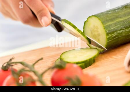 Woman chopping concombre. Banque D'Images