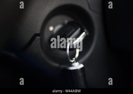 Ancienne clé de contact dans la serrure en position marche. Selective focus sur porte-clés. Trousseau d'alarme de voiture sur l'anneau de suspension. Démarrage du moteur automobile concept. Clos Banque D'Images