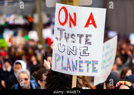 Une vue en gros plan d'une affiche en français, la lecture nous n'avons qu'une seule planète, tenue au-dessus d'une foule de militants de l'environnement au cours d'une manifestation de rue. Banque D'Images