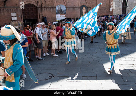 Les marcheurs en costume médiéval avec le batteur et les drapeaux à pied dans les rues de Sienne, Italie à l'assemblée annuelle de chevaux Palio historique et défilé Banque D'Images