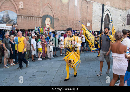 En costume médiéval homme marche dans les rues de Sienne à jouer de la batterie dans la procession avant l'événement annuel du Palio de Sienne, Italie Banque D'Images