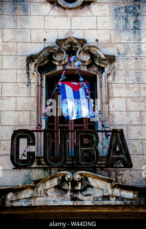 Drapeau cubain dans le vent en face d'un vieux théâtre cubain à La Havane, Cuba Banque D'Images