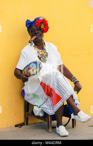 La femme cubaine costumés en costume traditionnel et pose un gros cigare de fumée Banque D'Images