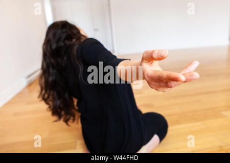 Un gros plan sur la main d'une jeune fille de race blanche comme elle effectue emotive danse se déplace seul dans un studio, son corps est vu flou en arrière-plan. Banque D'Images