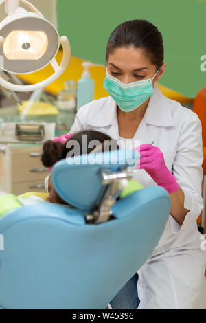 Femme sérieuse effectuant un concentré dentiste examen dentaire Banque D'Images