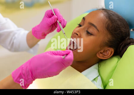 Belle jeune fille assise dans une chaise dentistes Banque D'Images