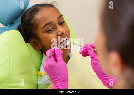 Jolie jeune femme assise avec une bouche ouverte Banque D'Images