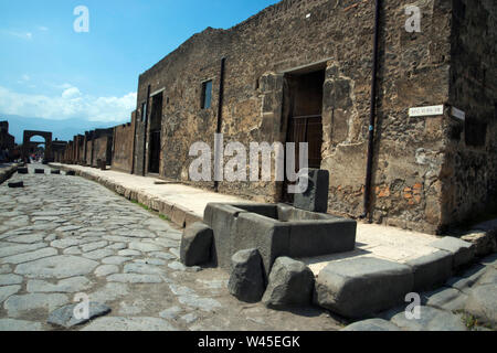 Pompéi, ITALIE, JUILLET 2018, à la rue avec trottoir, cobble-pierres, des maisons simples et réservoir d'eau en pierre. Banque D'Images