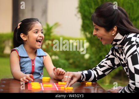 Girl playing tic tac toe with her mother Stock Photo