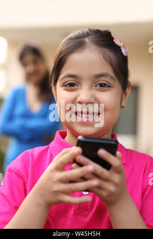 Portrait of a girl text messaging on a mobile phone Stock Photo