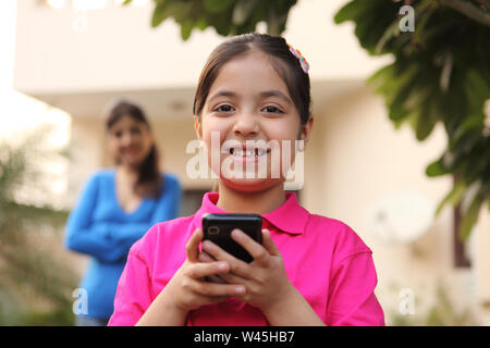 Portrait of a girl text messaging on a mobile phone Stock Photo