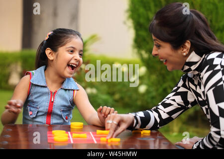 Girl playing tic tac toe with her mother Stock Photo