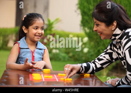 Girl playing tic tac toe with her mother Stock Photo