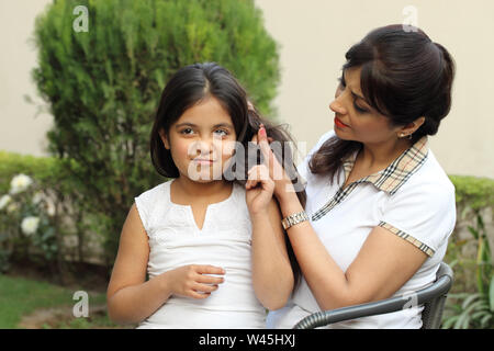 Femme peignant les cheveux de fille Banque D'Images