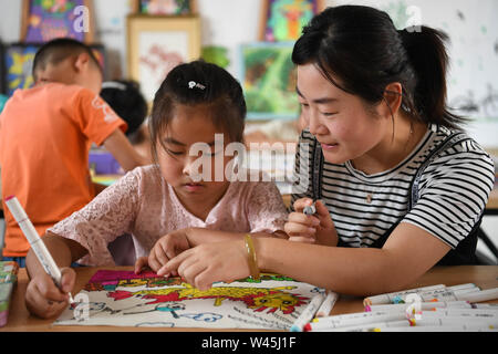 Feixi, la Province d'Anhui. 20 juillet, 2019. Zhao enseignants guides Butterfly Valley Resort un étudiant pour la peinture à l'École Centrale Ville Zipeng en comté Feixi, la Chine de l'est la province de l'Anhui, le 20 juillet 2019. L'école a organisé des cours axés sur l'intérêt libre telle que l'écriture, la musique et la peinture, pour les étudiants d'enrichir leurs vacances d'été. Credit : Liu Junxi/Xinhua/Alamy Live News Banque D'Images