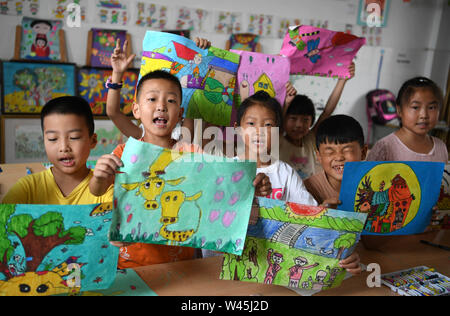 Feixi, la Province d'Anhui. 20 juillet, 2019. Les élèves montrent leurs peintures à l'École Centrale Ville Zipeng en comté Feixi, la Chine de l'est la province de l'Anhui, le 20 juillet 2019. L'école a organisé des cours axés sur l'intérêt libre telle que l'écriture, la musique et la peinture, pour les étudiants d'enrichir leurs vacances d'été. Credit : Liu Junxi/Xinhua/Alamy Live News Banque D'Images