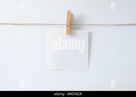 Un peu de feuille de papier par un presse-papiers sur une chaîne. Banque D'Images