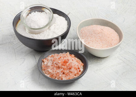 Différents types de sel sur fond gris. Banque D'Images