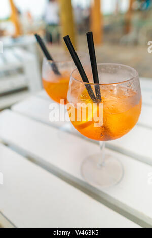 Délicieux cocktail aperol spritz glacé classique avec des cubes de glace sur une plage tropicale chaude dans le soleil d'été Banque D'Images