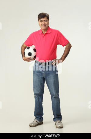 Portrait d'un homme tenant un ballon de foot Banque D'Images