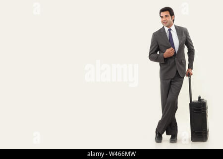 Businessman standing with suitcase Banque D'Images