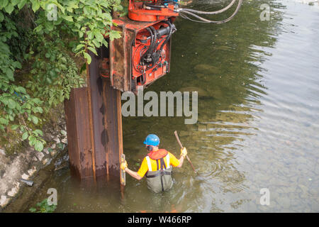 Un barrage temporaire en cours d'installation sur la rivière Kent à Kendal, Cumbria, pour permettre les réparations d'urgence à l'inondation endommagée Pont Victoria Banque D'Images