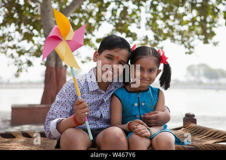 Boy holding pinwheel with his sister Stock Photo