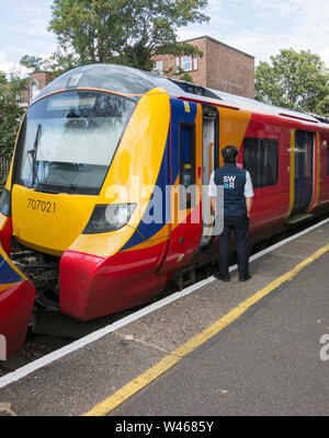 Une garde sur FirstGroup et MTR Corporation's South Western Railway train et wagons Banque D'Images