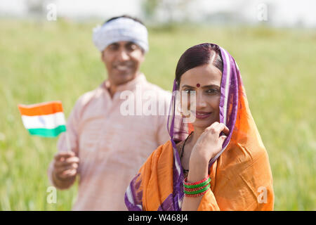 Portrait of a woman smiling avec son mari tenant un drapeau à l'arrière-plan Banque D'Images