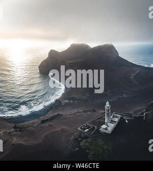 Vue sur volcan Capelinhos, phare de Ponta dos Capelinhos sur la côte ouest sur l''île de Faial, Açores, Portugal avec un coucher de soleil spectaculaire et fort Banque D'Images