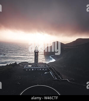 Vue sur volcan Capelinhos, phare de Ponta dos Capelinhos sur la côte ouest sur l''île de Faial, Açores, Portugal avec un coucher de soleil spectaculaire et fort Banque D'Images