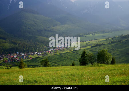 Beau paysage d'été sous le soleil du soir avec la petite ville Zdiar, dans l'arrière-plan les montagnes Tatra. La Slovaquie. Banque D'Images