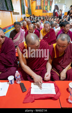 Les moines bouddhistes népalais partager livres de prière à un service au temple Kyidug Sherpa dans Elmhurst, Queens, New York. Banque D'Images