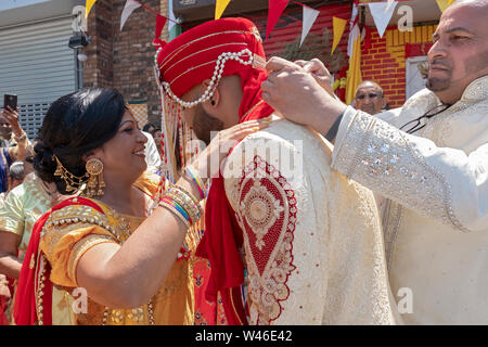 Lors d'une cérémonie de mariage traditionnelle hindoue le marié est accueilli par la mère de la mariée & oncle avant d'entrer dans le temple. En Ozone Park, Queens, NY Banque D'Images