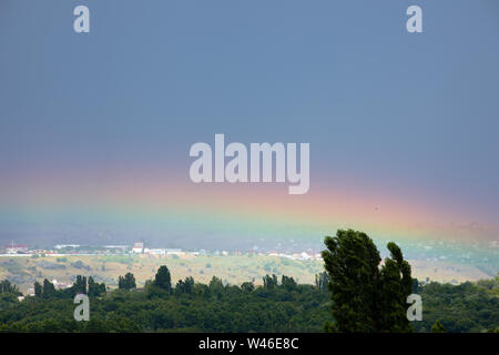 Arc-en-ciel sur les arbres verts, paysage ville d'été Banque D'Images