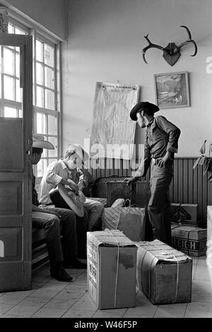 Cowboys années 1960, la gare routière Greyhound des États-Unis borde le Texas et le Mexique, franchissant la frontière avec Mexico1969. Cow-boys américains mexicains dans une gare routière de ville frontière mexicaine. Ils prennent les paquets sur le sol à la maison de l'autre côté de la frontière. HOMER SYKES Banque D'Images