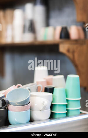 Différents tas de bleu, rose, blanc et vert sur les tasses machine à café dans le café. Barista concept. Arrière-plan de quartier branché hipster cafe. Banque D'Images