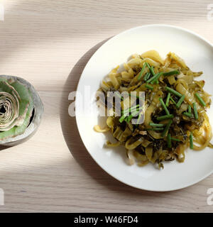 Plaque de maison, moutarde aigre ou acide avec de l'huile de cuisson de légumes fry et scallion sur fond blanc en vue de dessus Banque D'Images