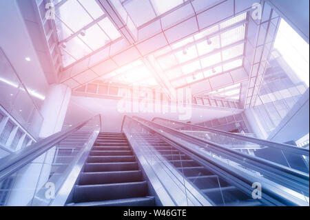 Escaliers mécaniques dans un centre d'affaires moderne. Image tonifiant bleu Banque D'Images