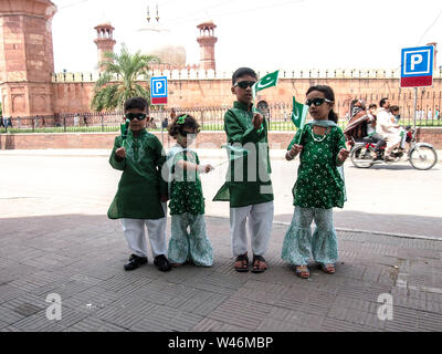 Enfants vêtus de couleurs vert et blanc robe et tenue en mains, drapeaux pakistanais Banque D'Images