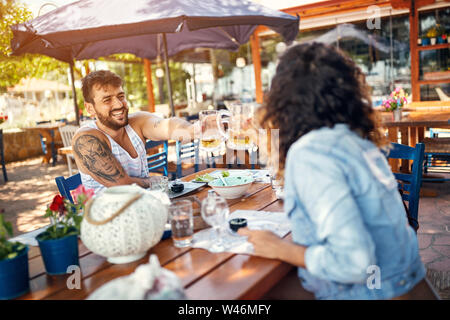 Beau couple d'amoureux assis dans un restaurant bénéficiant dans la bière et la conversation